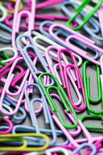istock Multicolored paper clips scattered as textured background 1761674400