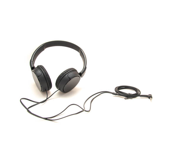istock Top view black wired headphone with swiveling earcup foam cushions, L-shaped stereo mini plug 3.5mm isolated on white background, corded kids headphones, technology accessories 1761675552