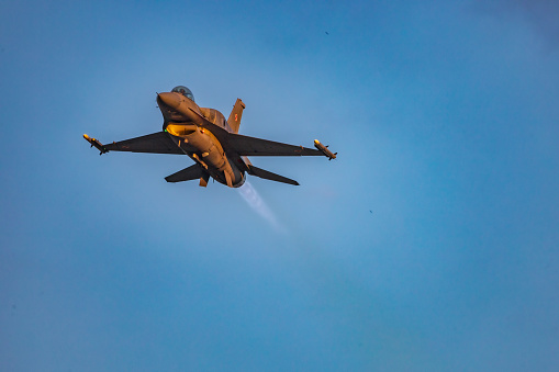 Leszno, Poland - June 17 2023: Antidotum Airshow Leszno 2023 and acrobatic shows full of smoke of F-16 Tiger Demo Team on a cloudy sky