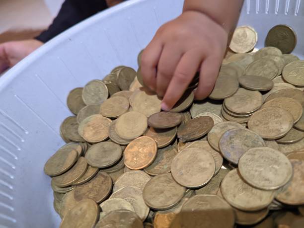 istock little boy playing with brass coins 1761702391