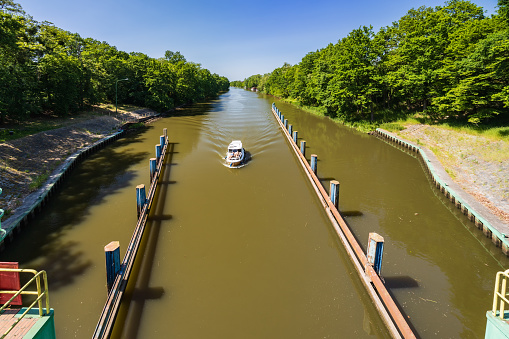 Wroclaw, Poland - June 4 2023: Beautiful view of boat entrance to water level mechanism with dirty water with beautiful green trees and bushes on both sides of river