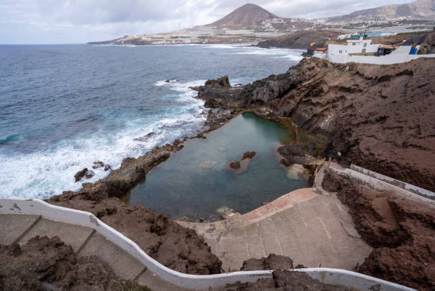 Top view of the natural pool known as "La Furnia" or "el Clavo" by the sea with the waves breaking on the barrier, near Galdar, on the island of Gran Canaria, Spain stock photo
