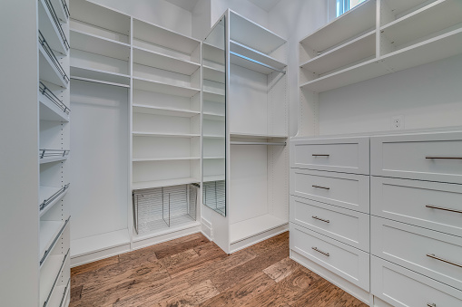 High ceiling in walk in closet with natural hardwood floors