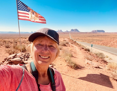 Selfie Shot of Woman in Front of Monument Valley and USA Flag