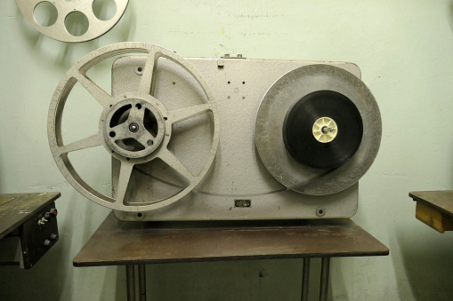 Vintage film rewinding device in old movie theater.