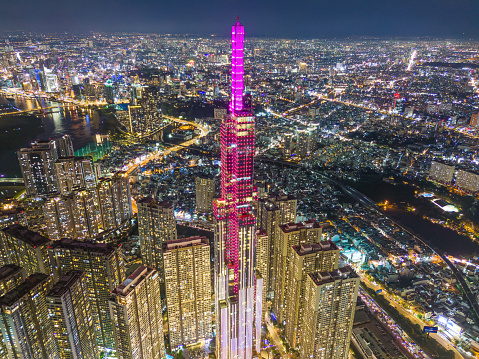 Aerial sunset view at Landmark 81 - it is a super tall skyscraper and Saigon bridge with development buildings along Saigon river, cityscape in the night. Travel and business concept