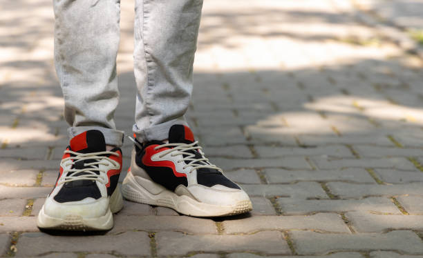 istock Stylish children's colored sneakers on feet close-up, copy space. 1761751390