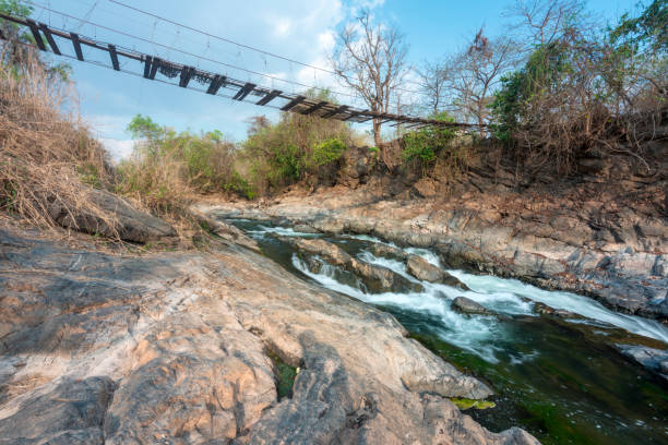 istock Broken basic wooden suspension footbridge,cossing a narrow river,Don Khone,4000 Islands,Southern Laos. 1761763321