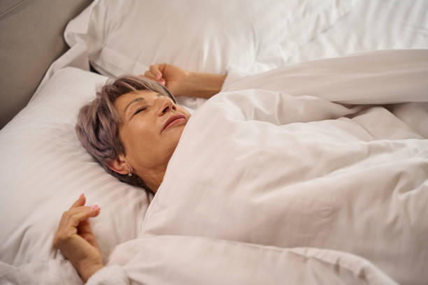 istock Gray-haired woman is dozing in a soft bed 1761871682