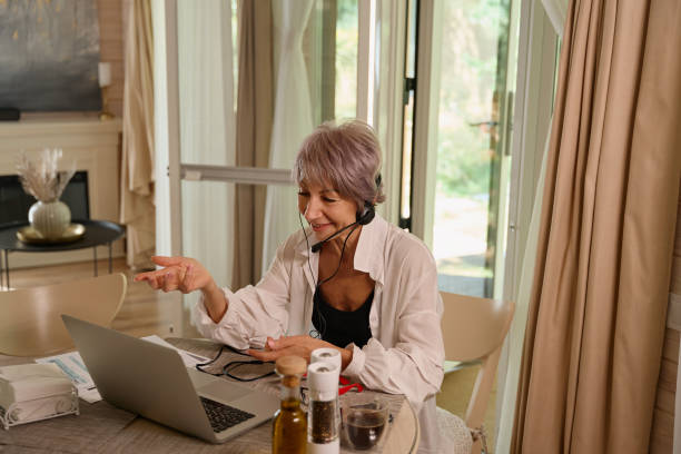 istock Elderly lady is pleasantly communicating online in her kitchen 1761872333