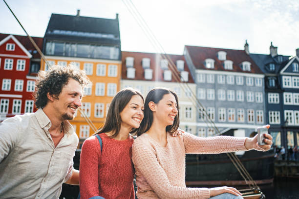 istock Three friends taking selfies by the Stromma Canal in Copenhagen 1761876805