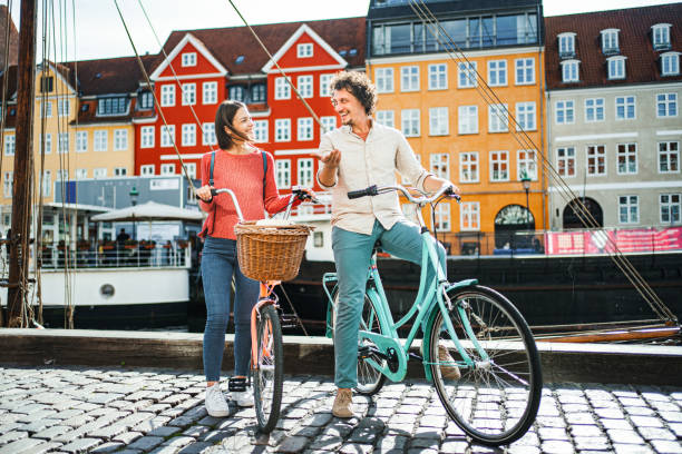 istock Young romantic couple with their bicycles standing by the Stromma Canal in Copenhagen 1761879310