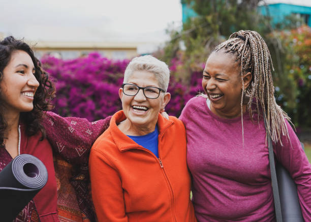 istock Multi generational women having fun hugging each other after yoga class at city park - Multiracial female friends, healthy lifestyle and community concept 1761879318