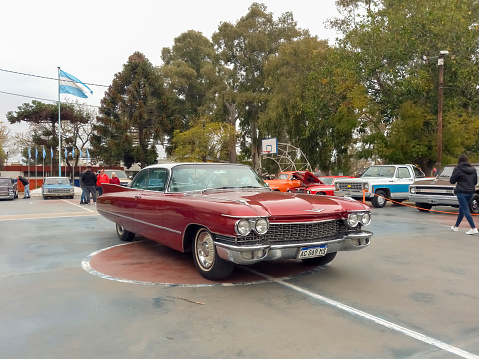 Lanús, Argentina - Sept 24, 2023: Old red luxury 1960 Cadillac coupe DeVille at a classic car show in a park.