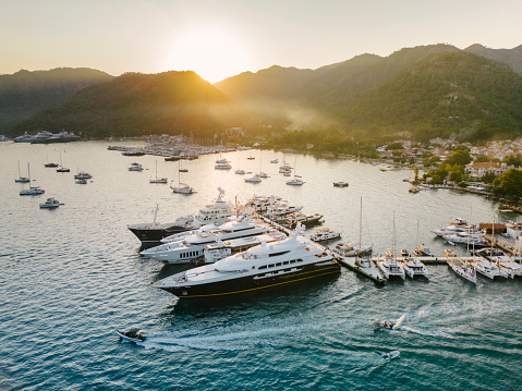parking of boats in a marina in a small town on the Mediterranean coast in the rays of the setting sun. Luxury mega yachts