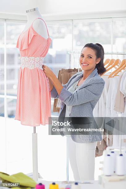 Photo libre de droit de Joyeux Styliste Mesurant Une Robe Sur Un Mannequin banque d'images et plus d'images libres de droit de A la mode - A la mode, Affaires, Affaires d'entreprise