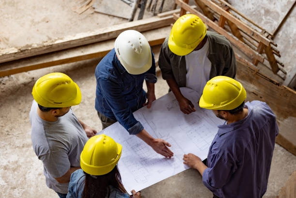 istock Contractor looking at blueprints with a group of construction workers 1761958151