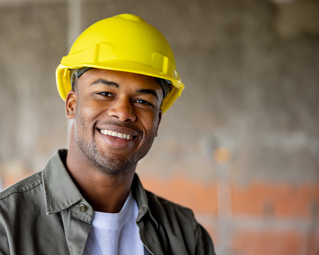 Portrait of a happy African American construction worker looking at the camera and smiling - building site concepts
