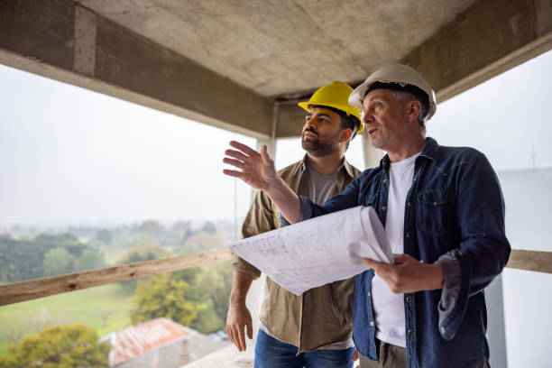 istock Team of construction workers looking at blueprints at a construction site 1761958175