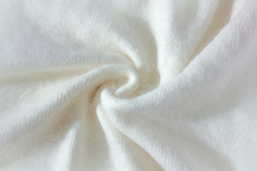 Swirl Background texture of white pattern knitted fabric made of angora and wool close up.
