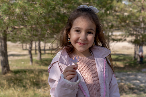 Portrait of a girl in the woods. Girl in green nature. Girl having fun in the forest. Life in nature.