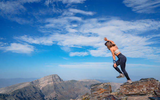 istock Young female mountain climber is losing her balance while meditating  ,doing yoga and stretching exercises on the top of the summit of a mountain. 1761984202