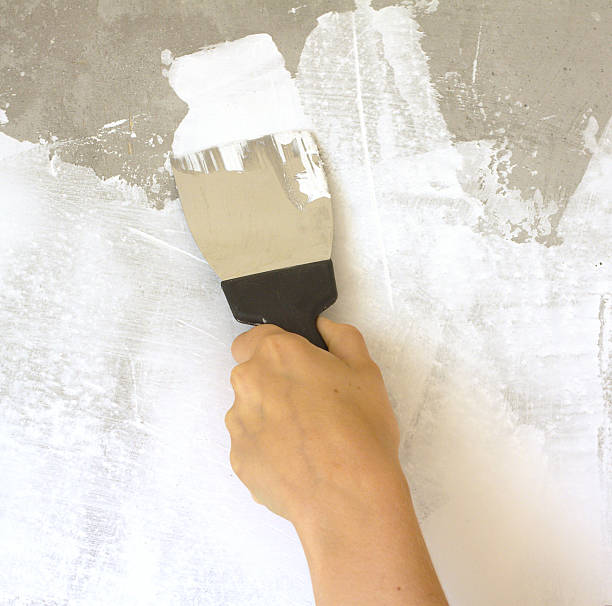 istock Woman's hand with a spatula plasters wall 176198927