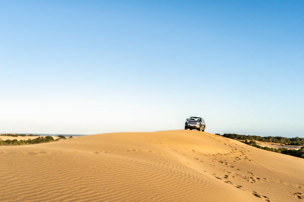istock A man driving a 4x4 vehicle in a dune at sunset . Copy space 1761999375