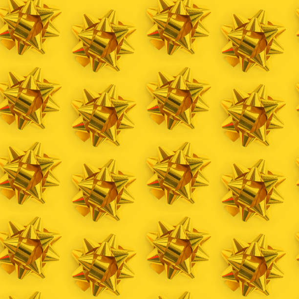 istock Seamless yellow pattern of gold bows. Trending Christmas pattern view from above. 1762002061