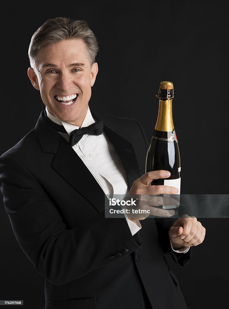 Веселый человек в стиле смокинга, держит Бутылка шампанского - Стоковые фото 40-44 года роялти-фри