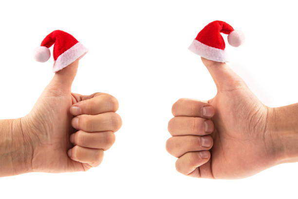 Thumb up hand sign with Santa hat isolated on white background