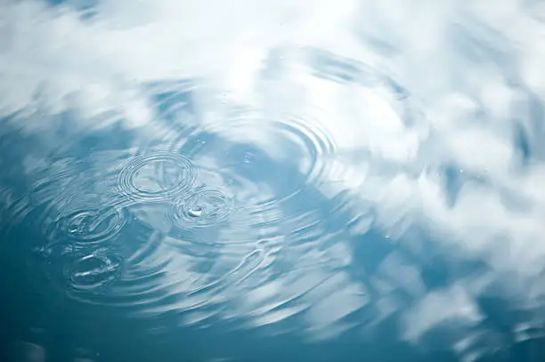 Rippled water abstract with cloud reflection.