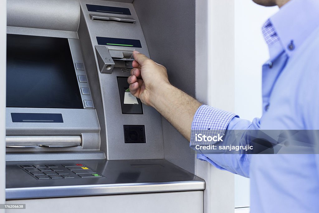 Man using a ATM Hand of man with credit card, using a ATM ATM Stock Photo