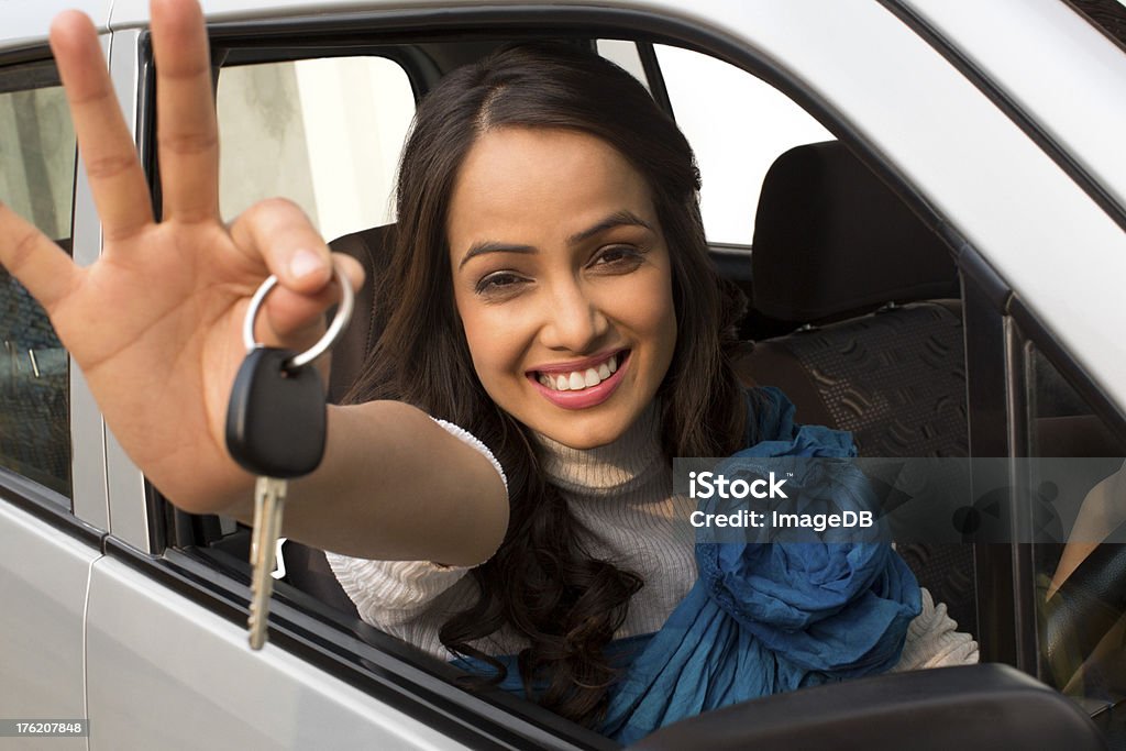 woman showing a car key Portrait of a woman showing a car key while sitting in a car Indian Ethnicity Stock Photo