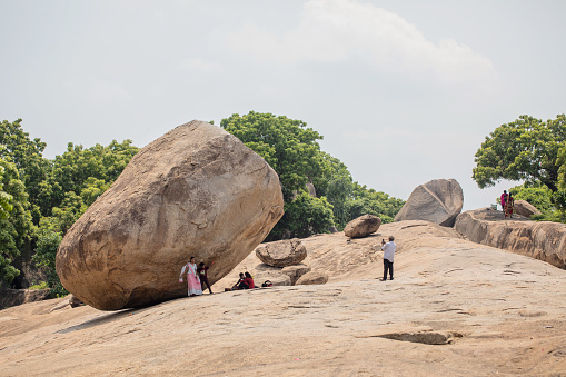 Mahabalipuram, India - October 3, 2023. Visitors take photos by Krishna's Butterball in Mahabalipuram, a seaside town in Tamil Nadu, India.