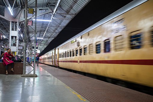 Chennai, India - October 7, 2023. A passenger train pulls into the station Chennai Central at nighttime.