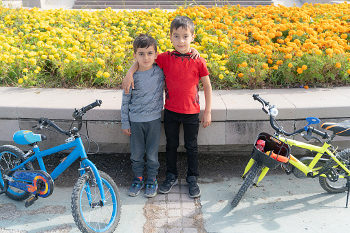 The brothers spend time with their bicycles in the city park. Children ride bicycles in the park on the weekend. Taken in daylight with a full frame camera.