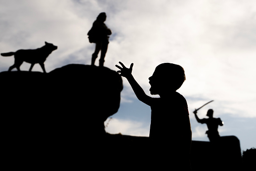 Silhouette photo of heroic characters in the children's playground in the public park. The background is the sky. Shot with a full frame camera.