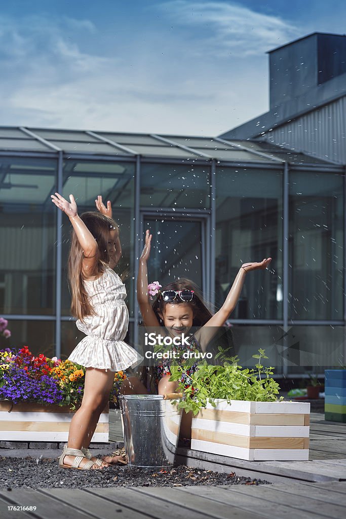 Маленькие Сестры плескание воды из ведро - Стоковые фото 4-5 лет роялти-фри