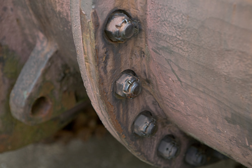 This pipe shows texture and is rusty with bolts. This could be used as a background. The metal industrial look of steal or metal that is aged.