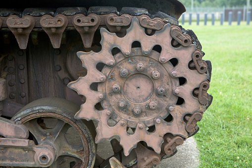This old rusty gear could be used for a background or grunge image. The star-shaped gear is used to drive a tank track. Detailed angles and intricate gear design shown.