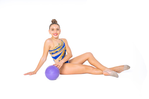 Teenage girl practicing rhythmic gymnastics doing ball exercises