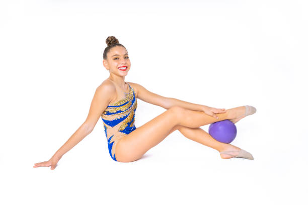 Teenage girl practicing rhythmic gymnastics doing ball exercises