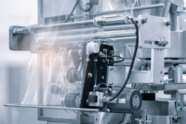 istock Automatic polyethylene plastic bag production machine with lighting effect. Close-up of the roller of the plastic bag production machine in the light blue scene. product packaging concept 1762198204