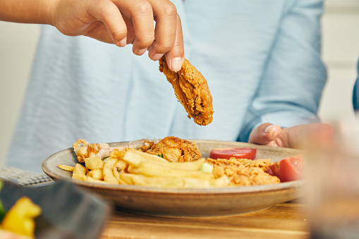 A beautiful & happy mixed-race couple, asian and black, enjoying a barbecue brunch made of fried chicken, French fries, fresh tomato and green salad, salad with figs and spinach, showing positivity and happiness, sharing and representing love, joy, wellbeing, true couple friendship, security, trust and togetherness