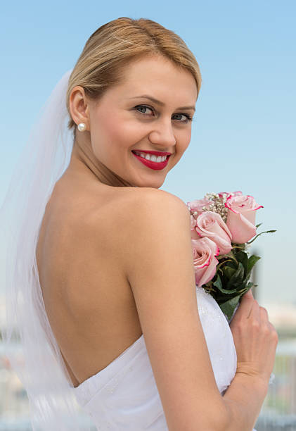 istock Beautiful Bride Holding Flower Bouquet Against Sky 176231362