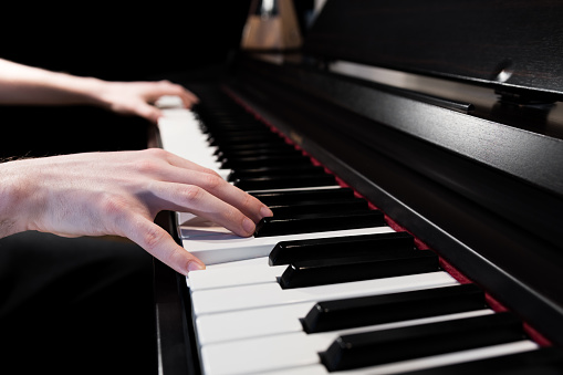 Close up of a piano player's hands. Person playing the keyboard musical instrument