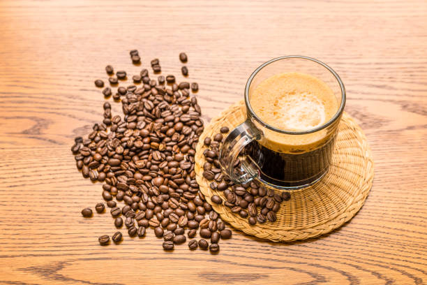 istock Cup of Fresh Coffee On a Rustic Wood Grain Table with Coffee Beans Background 1762339790