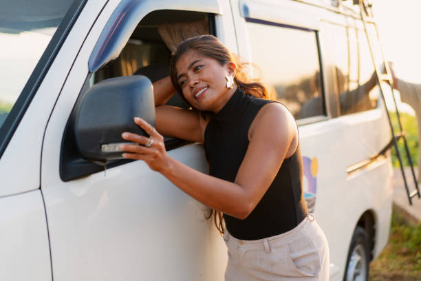 istock Southeast Asian Woman Checking Rear View Mirror on a Van At Sunset 1762346947