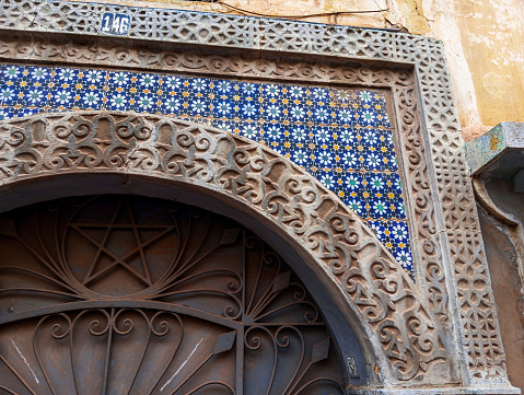 Old moroccan traditioal ornamented entrance of a house. Moroccan decorative building entrance.